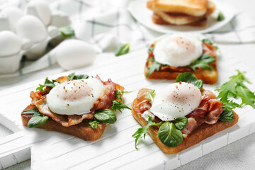 Tasty eggs Benedict on cutting board