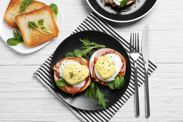 Fototapeta na wymiar Tasty eggs Benedict on plate, top view