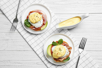 Tasty eggs Benedict on plates, top view