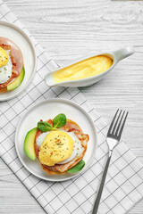 Tasty eggs Benedict on plates, top view