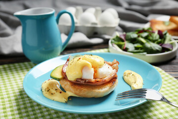 Egg Benedict with fork on plate, closeup