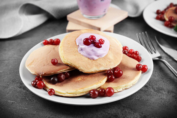 Tasty pancakes with yogurt and berries on table