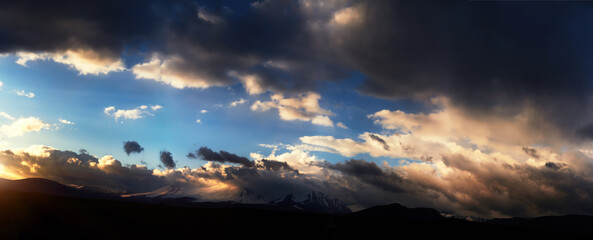 Altai Ukok the sunset over the mountains in cloudy cold weather. Wild remote places, no one around. Rain clouds over the mountains