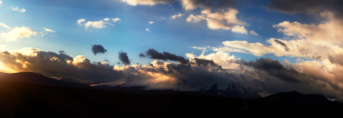 Altai Ukok the sunset over the mountains in cloudy cold weather. Wild remote places, no one around. Rain clouds over the mountains