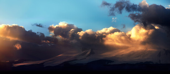 Altai Ukok the sunset over the mountains in cloudy cold weather. Wild remote places, no one around. Rain clouds over the mountains
