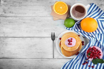 Tasty pancakes with yogurt and fruits on table