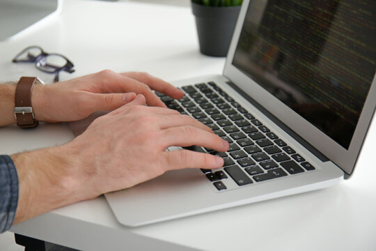 Male hands on laptop keyboard, closeup