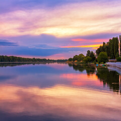 Fototapeta na wymiar Vivid scenery of sunset at the river, colorful, dramatic evening sky reflected in the water, hdr image. Khmelnytskyi, Ukraine