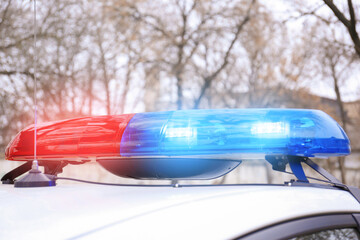 Police car with flasher on street, closeup