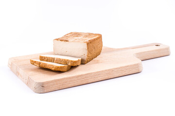 Slices of soy cheese tofu on a cutting board
