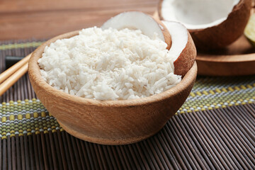 Wooden bowl with coconut rice on bamboo mat