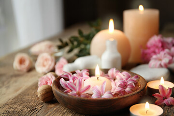 Fototapeta na wymiar Beautiful spa composition with flowers and candles on wooden table