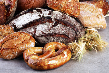 freshly baked bread. Different kinds of bread and bread rolls on board from above. Kitchen or bakery poster design.