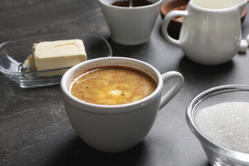 Cup of coffee with butter on table