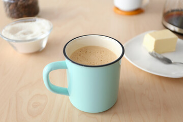 Cup of coffee with butter on table
