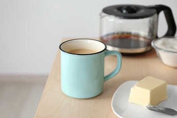Cup of coffee with butter on table