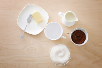 Composition with empty cup, coffee and butter on wooden table