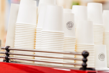 Rows of upside down white cups of cardboard for beverages, disposable tableware for caffee, tee,...