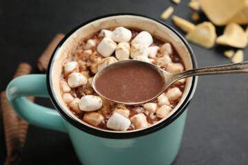 Spoon with tasty cocoa drink, closeup