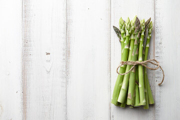 Bunch of fresh asparagus on white wooden background, copyspace
