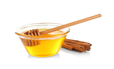 Cinnamon sticks and honey in glass bowl isolated on white