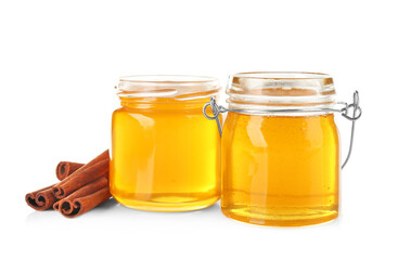Cinnamon sticks and honey in jars isolated on white