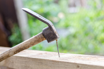 Using hammer and nail on wood and bokeh background