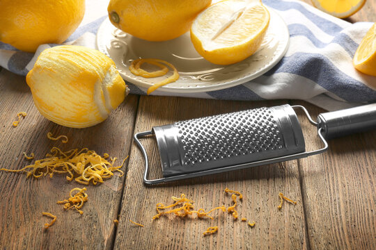 Grater and lemons on wooden table