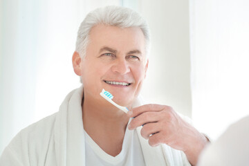 Senior man cleaning teeth at home