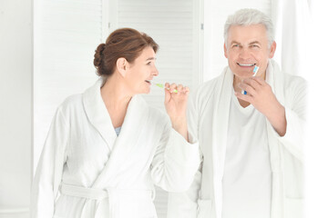 Obraz na płótnie Canvas Senior couple cleaning teeth at home