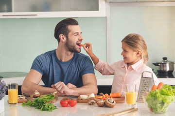 Young father and daughter cooking meal together 