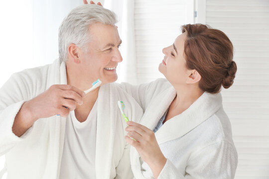 Senior couple cleaning teeth at home