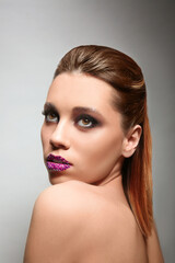 Fototapeta premium Beautiful young woman with creative makeup on color background
