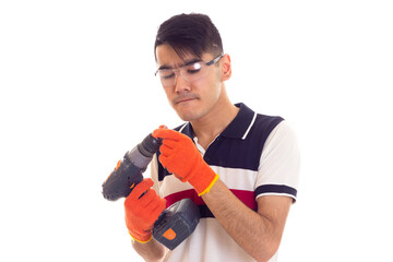 Young man with gloves and glasses holding electric screwdriver