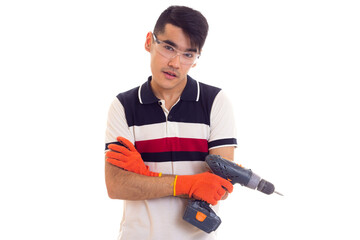 Young man with gloves and glasses holding electric screwdriver