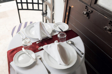table setting for a lovey dinner. Empty glasses set in restaurant. Part of interior. napkins, plates, and cutlery.