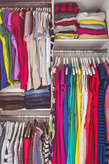 Home closet bedroom clean wardrobe of women fashion clothing hanging on racks. Woman clothes.