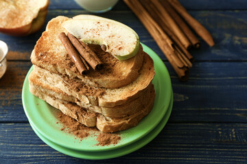 Plate with tasty cinnamon toasts on wooden table