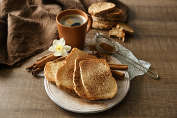 Plate with tasty cinnamon toasts on wooden table