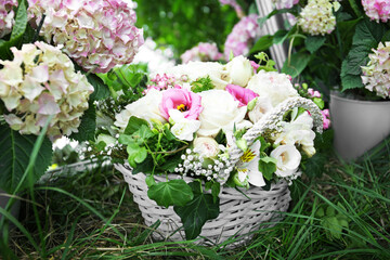 Wicker basket with beautiful flowers in spring garden