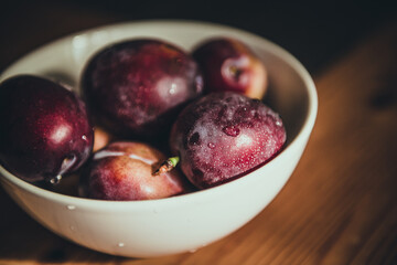 Fresh plums in bowl.