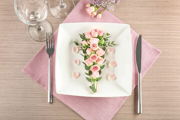 Beautiful festive table setting with floral decor on wooden surface