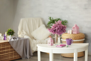 Fototapeta na wymiar Glass vase with beautiful lilac flowers on table