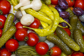 Background of pickled cucumbers, tomatoes, garlic, pepper, onions, cabbage close-up