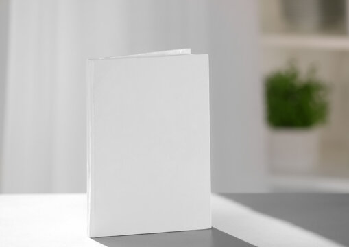 Book with blank cover on blurred background