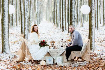Winter wedding newlyweds sitting at a decorated table in rustic style