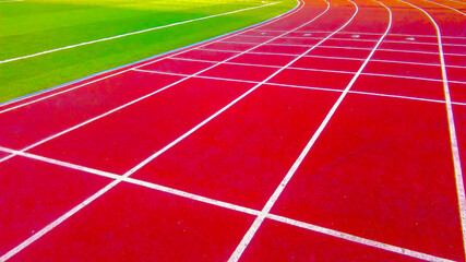 Red running tracks in sport stadium in autumn park
