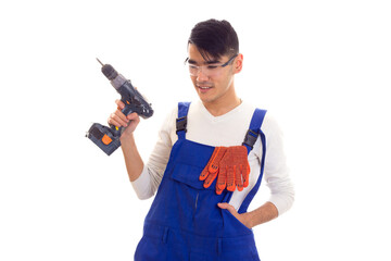 Man in overall with gloves and glasses holding electric screwdriver