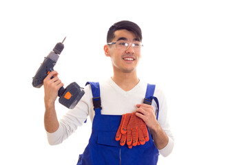 Man in overall with gloves and glasses holding electric screwdriver