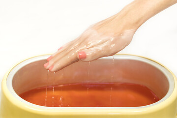 Process paraffin treatment of female hands in beauty salon 